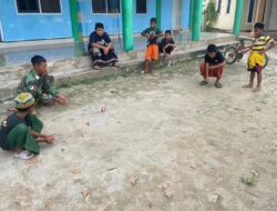 Jalin Kedekatan Dengan Anak-anak, Anggota Satgas TMMD Ke-120 Ikut Main Kelereng